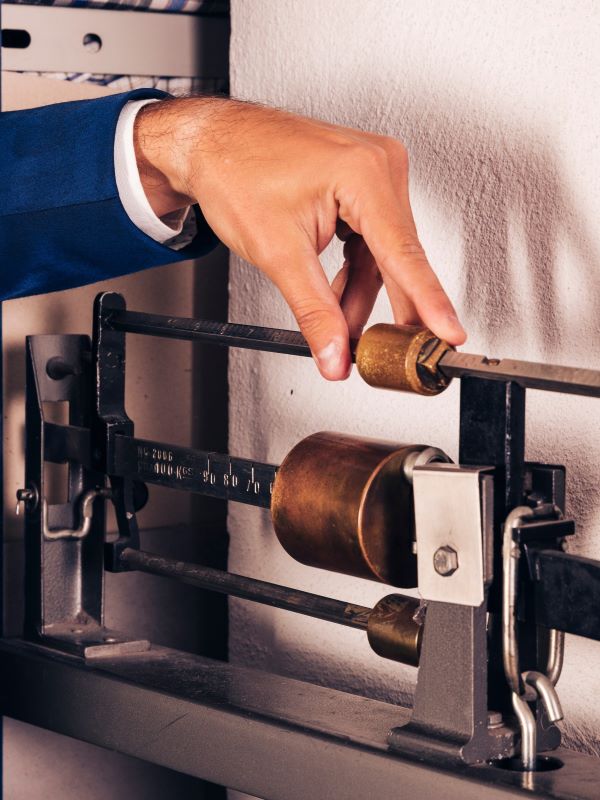 Technician adjusting a mechanical balance scale in the workshop
