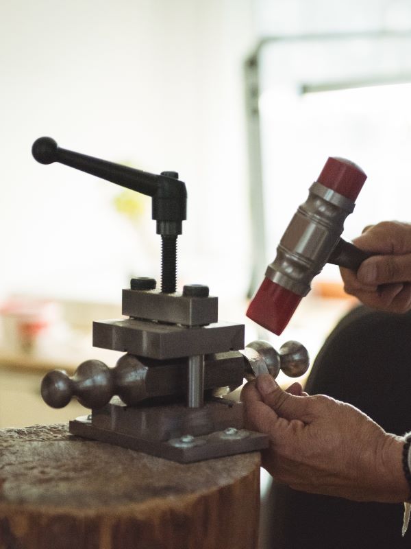 Metalworking with a mallet and hand tools in the spare parts area